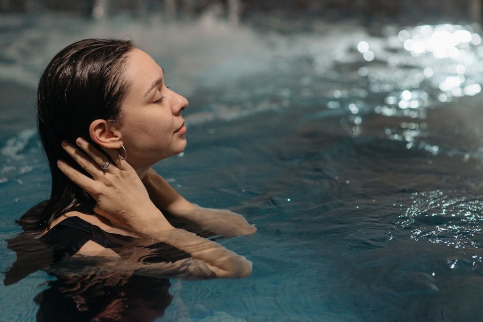 Vrouw neemt een koude douche bij zonsopgang Vrouw neemt een koude douche bij zonsopgang
